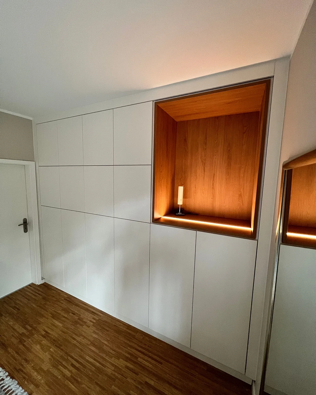 Raumhoher Einbauschrank mit beleuchteter Holznische
